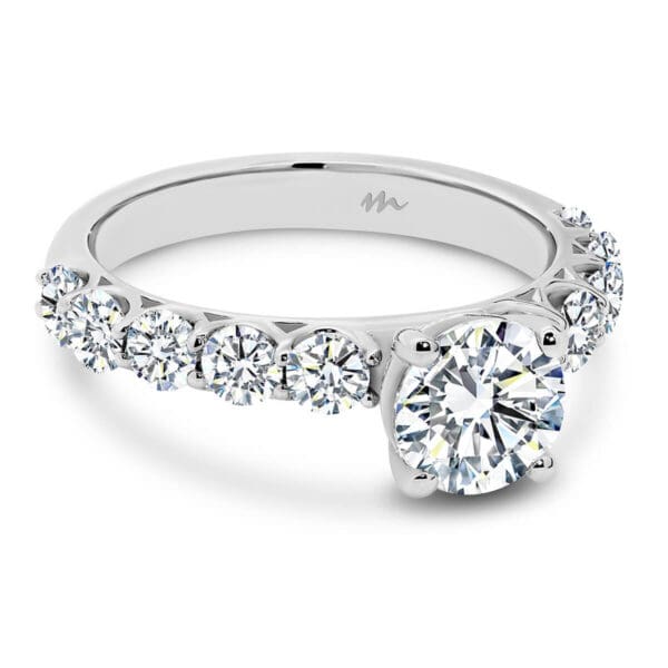 Maxine 6.5-7.0 Moissanite Engagement Ring With Round Stone On 4-Prong Setting On Prong Set Band Of Stones