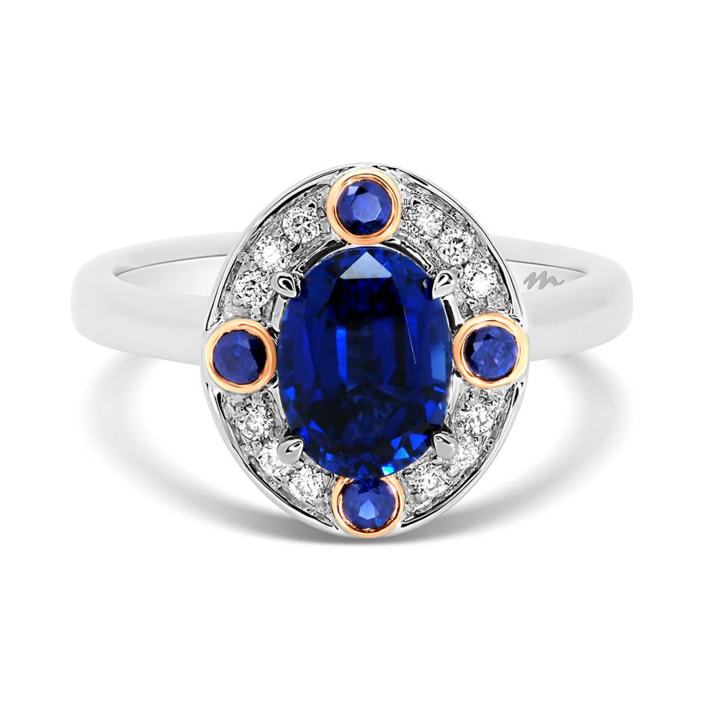 Clover Oval Blue halo design in two-tone gold with lab-grown sapphire centre stone & halo with 4 bezel set sapphires