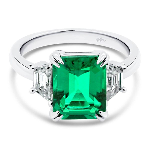 Aubrey Emerald 9x7-10x8 Emerald trilogy with trapezoid side stones on plain band