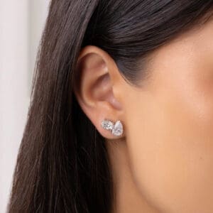 Model Wears Amelie Grande 9X6 White Gold Moissanite Oval Pear Cut Prong Toi Et Moi Earrings