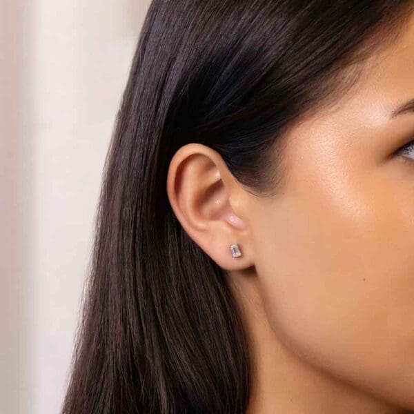 Model Wears Karla Emerald 5X3 White Gold Moissanite Prong Set Stud Earrings