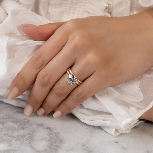 Model Wears Angela 1.5 Yellow Gold Diamond U Prong Half Set Wedding Band Fiona Round 8.5 Moissanite 4 Prong Solitaire Ring