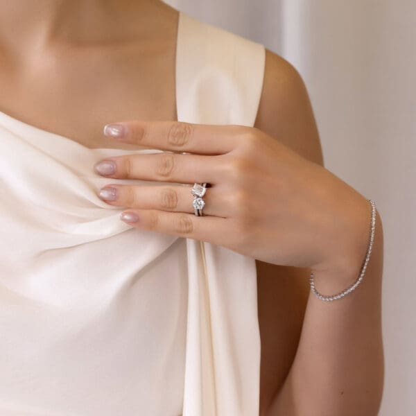 Model Wears Annerley 6.5 Solitaire Knife Edge Odette 8X6 White Gold Moissanite Emerald Interlocking Prong Set Toi Et Moi Ring
