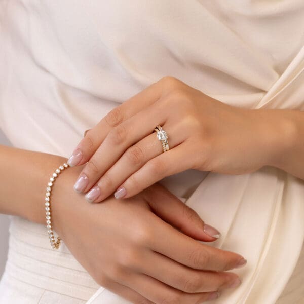 Model Wears Bonnie Yellow Gold Diamond Semi Bezel Set Wedding Band Victoria Cushion 7.0 Moissanite Open V Prong Ring