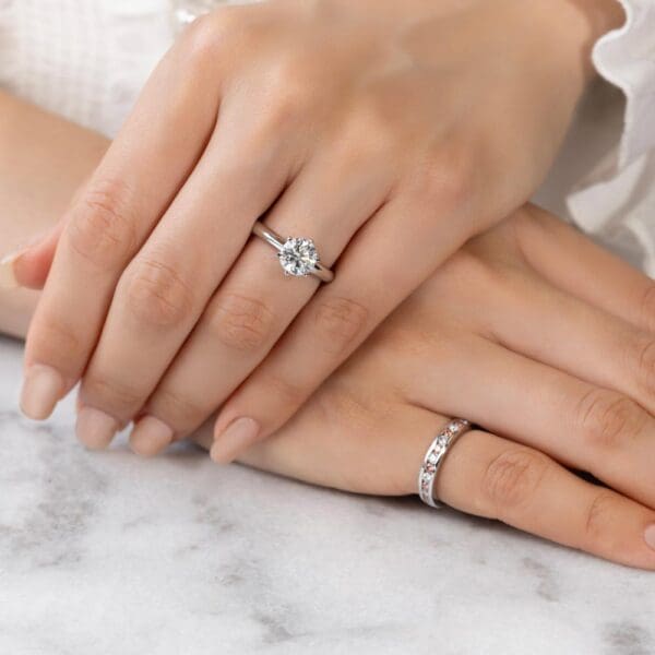 Model Wears Carmen 2.0 White Gold Alternating Pink Diamond Channel Set Wedding Band Audrey 7.5 Moissanite Solitaire Ring