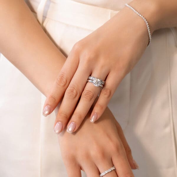 Model Wears Carmen 2.5 White Gold Diamond Channel Set Wedding Band Fiona Round 9.0 Moissanite 4 Prong Solitaire Ring