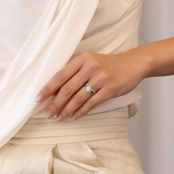 Model Wears Freya A White Gold Diamond Prong Set V Shaped Wedding Band Felicity 6.5 Infinity Crossover Solitaire Ring