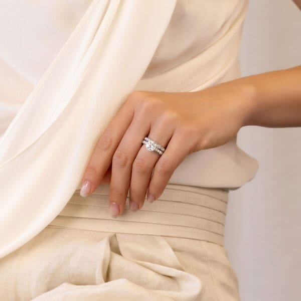 Model Wears Isabelle A White Gold Diamond Half Pave Set Wedding Band Isabelle 8.0 Moissanite Round Ring