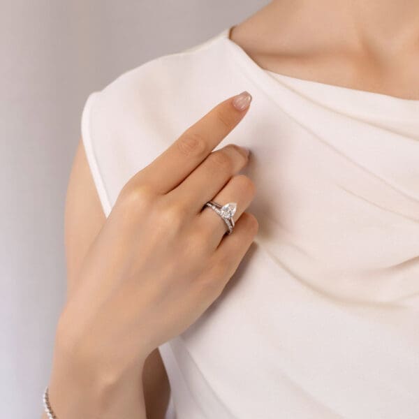 Model Wears Madison White Gold Diamond Bezel Set Round Scalloped Band Hattie Pear 10X7 Moissanite Stone Set Under Rail Ring