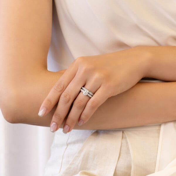 Model Wears Marissa A White Gold Diamond 3 Sided Pave Set Wedding Band Marissa Oval 8X6 Moissanite Four Prong Ring