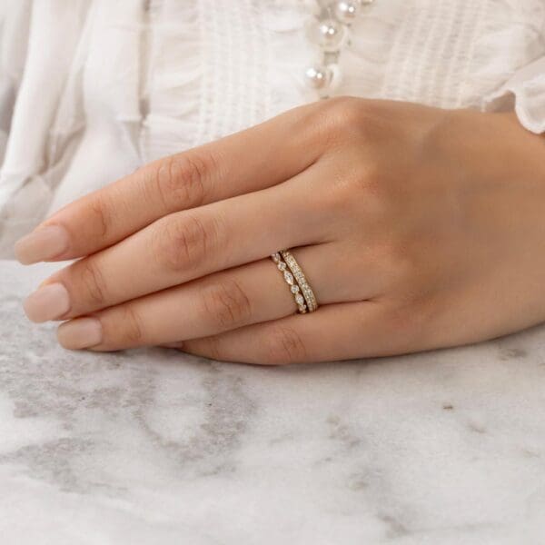 Model Wears Millie 1.5 Yellow Gold Lab Grown Diamond Pave Set Wedding Band Evie Marquise Round Shared Prong Wedding Ring