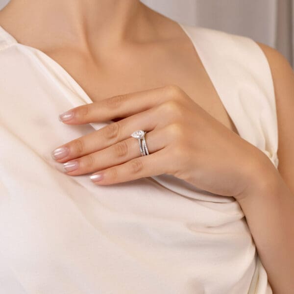 Model Wears Tessa White Gold Moissanite Crossover Prong Wedding Band Hattie Pear 10X7 Stone Set Under Rail Bridge Ring Highres
