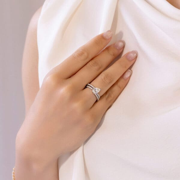 Model Wears Platinum White Gold Moissanite Angela 1.5 U Prong Set Band Florette 9X6 Pear Interlocking Toi Et Moi Ring