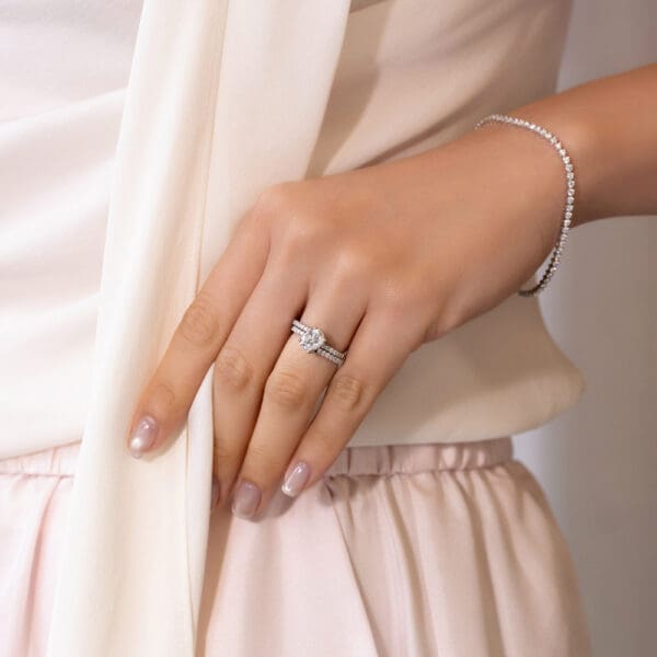 Model Wears Platinum White Gold Moissanite Angela 1.5 U Prong Set Wedding Band Claire 8X6 Oval Interlocking Toi Et Moi Ring