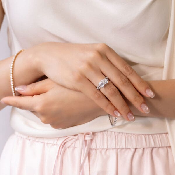 Model Wears White Gold Moissanite Evie Marquise Round Shared Prong Wedding Band Esme 9X6 Emerald Pear Toi Et Moi Ring