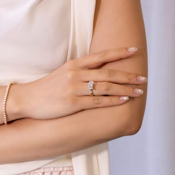 Model Wears Yellow Gold Moissanite Angela 2.0 U Prong Set Wedding Band Charlotte 9X6 Princess Pear Cut Toi Et Moi Ring