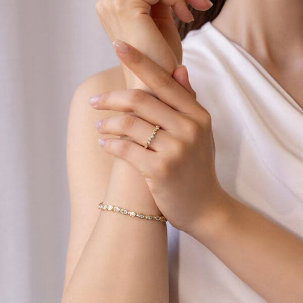 Model Wears Jodie Yellow Gold Moissanite Asymmetrical Round Bezel Set Band Wedding Ring Petra Diamond Oval Tennis Bracelet
