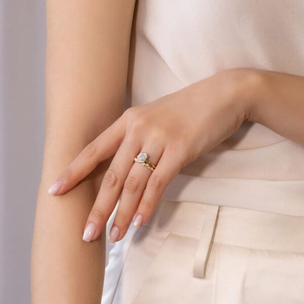 Model Wears Lottie Oval 8X6 Yellow Gold Moissanite Solitaire Ring Jodie Asymmetrical Round Bezel Set Wedding Band