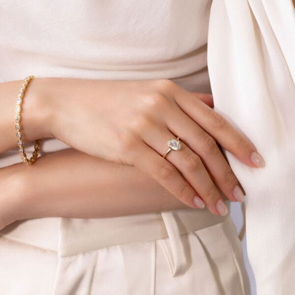 Model Wears Lottie Oval 9X7 Yellow Gold Moissanite Bezel Rounded Band Solitaire Ring