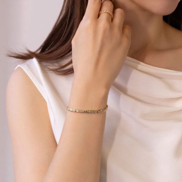 Model Wears Perrine Yellow Gold Lab Grown Diamond Emerald Bezel Tennis Bracelet