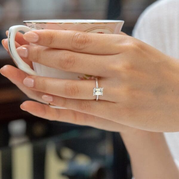 Model Wears Lydia Emerald 8X6 Diamond Classic Open V Gallery Rounded Band Solitaire Ring