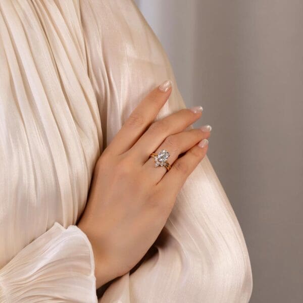 Model Wears Primrose Oval 9X7 Yellow Gold Moissanite Accented Bridge Petal Basket Ring Sofie Pear Round Tiara Jigsaw Band