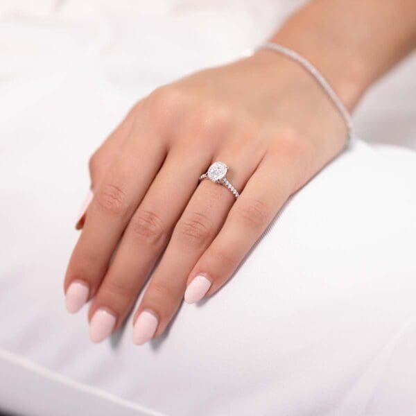 Model Wears Harmony Oval 9X7 White Gold Moissanite 4 Prong Accented Under Rail Bridge Engagement Ring